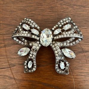 An Eisenberg rhinestone bow brooch. Missing 11 little stones.